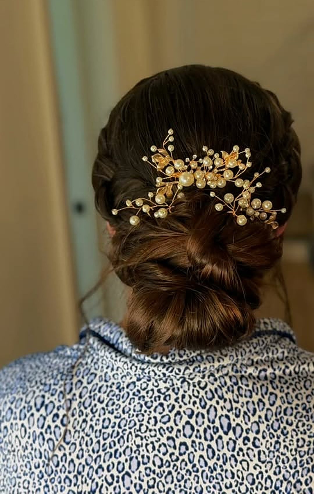 Low bridal bun with a gold pearl hairpiece