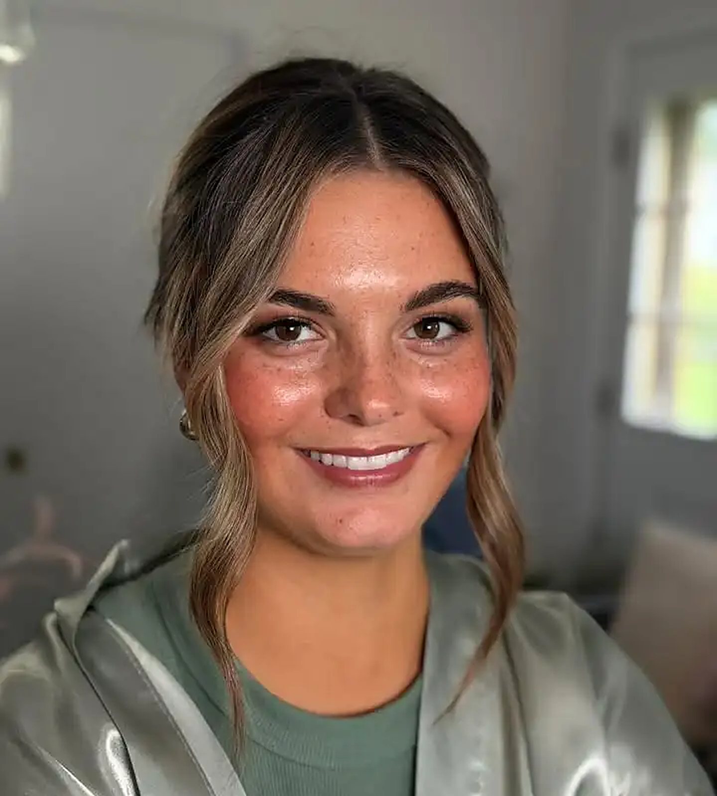 Client with glowy, bronzed airbrush makeup and soft face-framing waves
